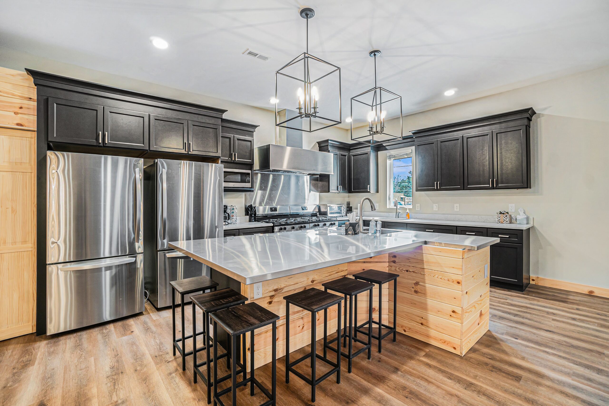 Spacious and modern kitchen with stainless steel appliances at Timbertown Lodge in Lewiston, Michigan. 2 gas ranges, 2 refrigerators and 2 dishwashers